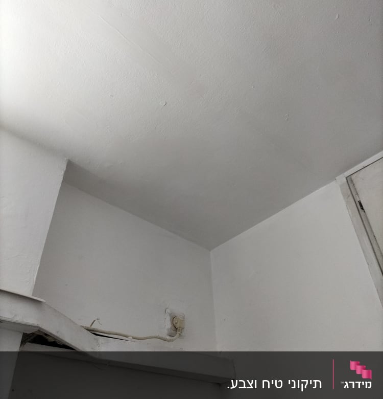 שקע חשמל על קיר לבן עם חוטים חשופים